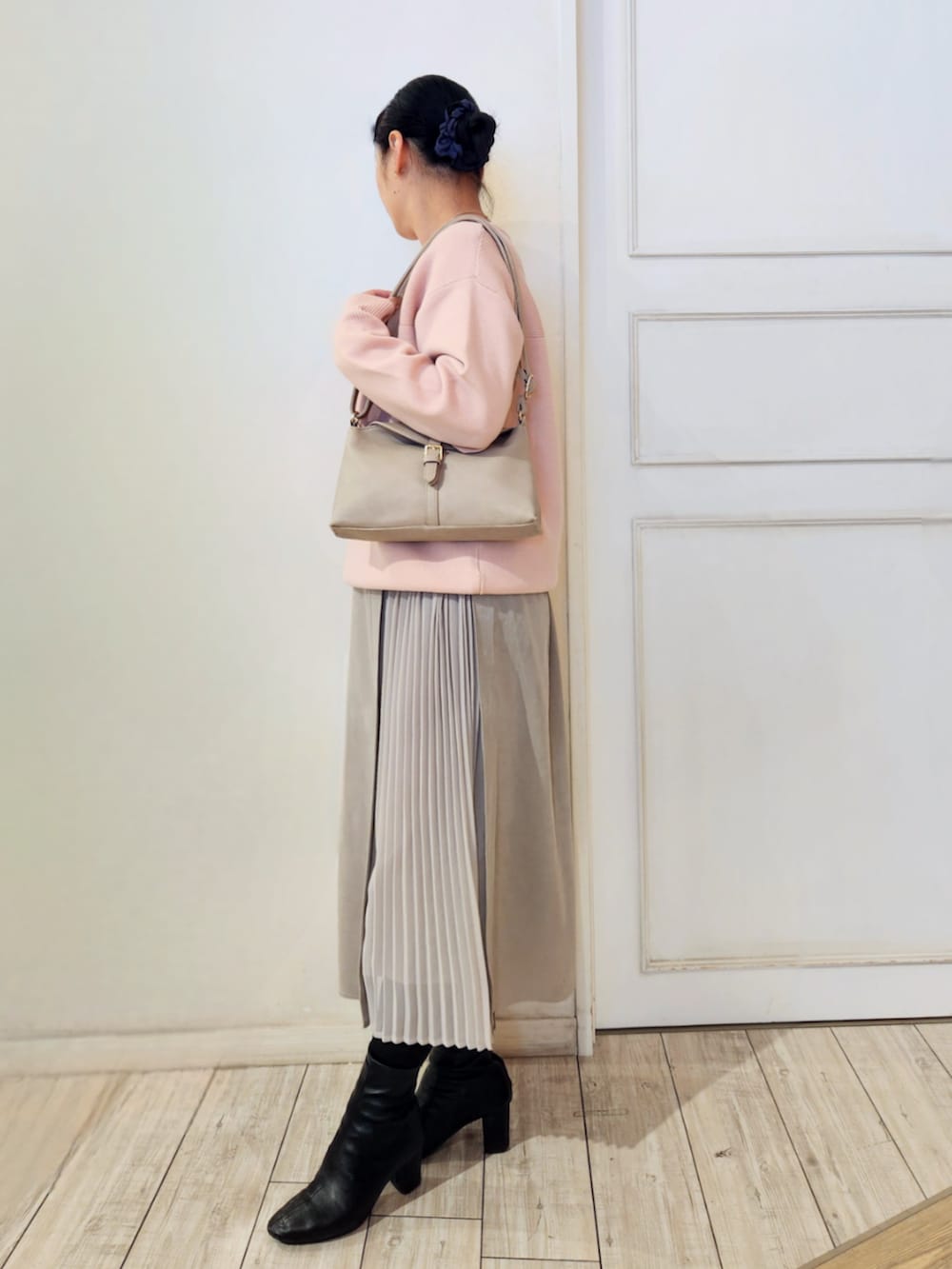 ブラック系のブーツ、ベージュ系のスカート、グレー系のショルダーバッグを着用したレディースの冬コーディネートの2枚目の写真