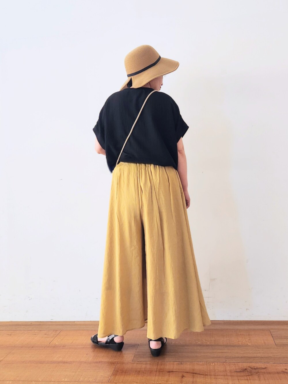 グレー系のショルダーバッグ、ブラック系のTシャツ/カットソー、イエロー系のその他パンツを着用したレディースの夏コーディネートの4枚目の写真