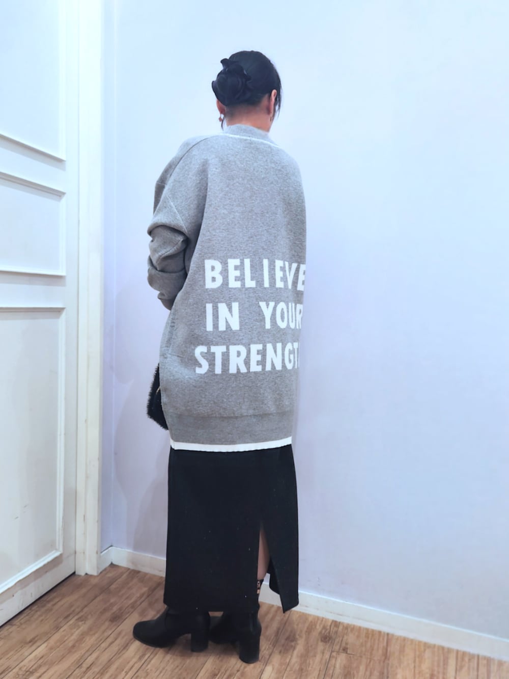 ブラック系のブーツ、ブラック系のスカート、ブラック系のショルダーバッグを着用したレディースの冬コーディネートの3枚目の写真