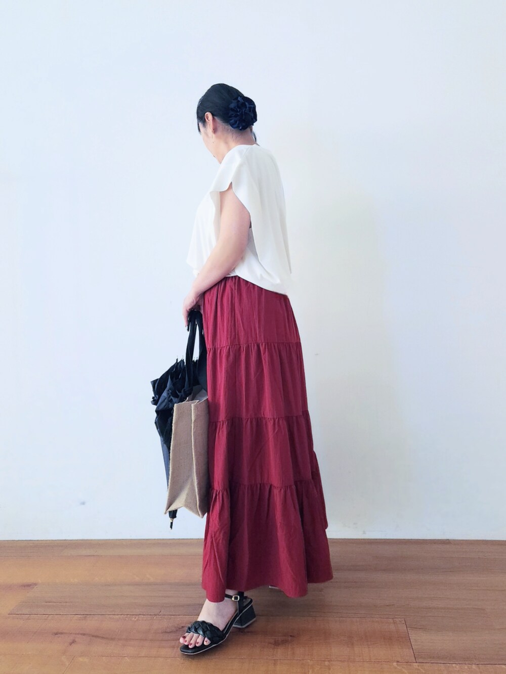 ブラック系のトートバッグ、レッド系のスカート、ホワイト系のTシャツ/カットソーを着用したレディースの夏コーディネートの3枚目の写真