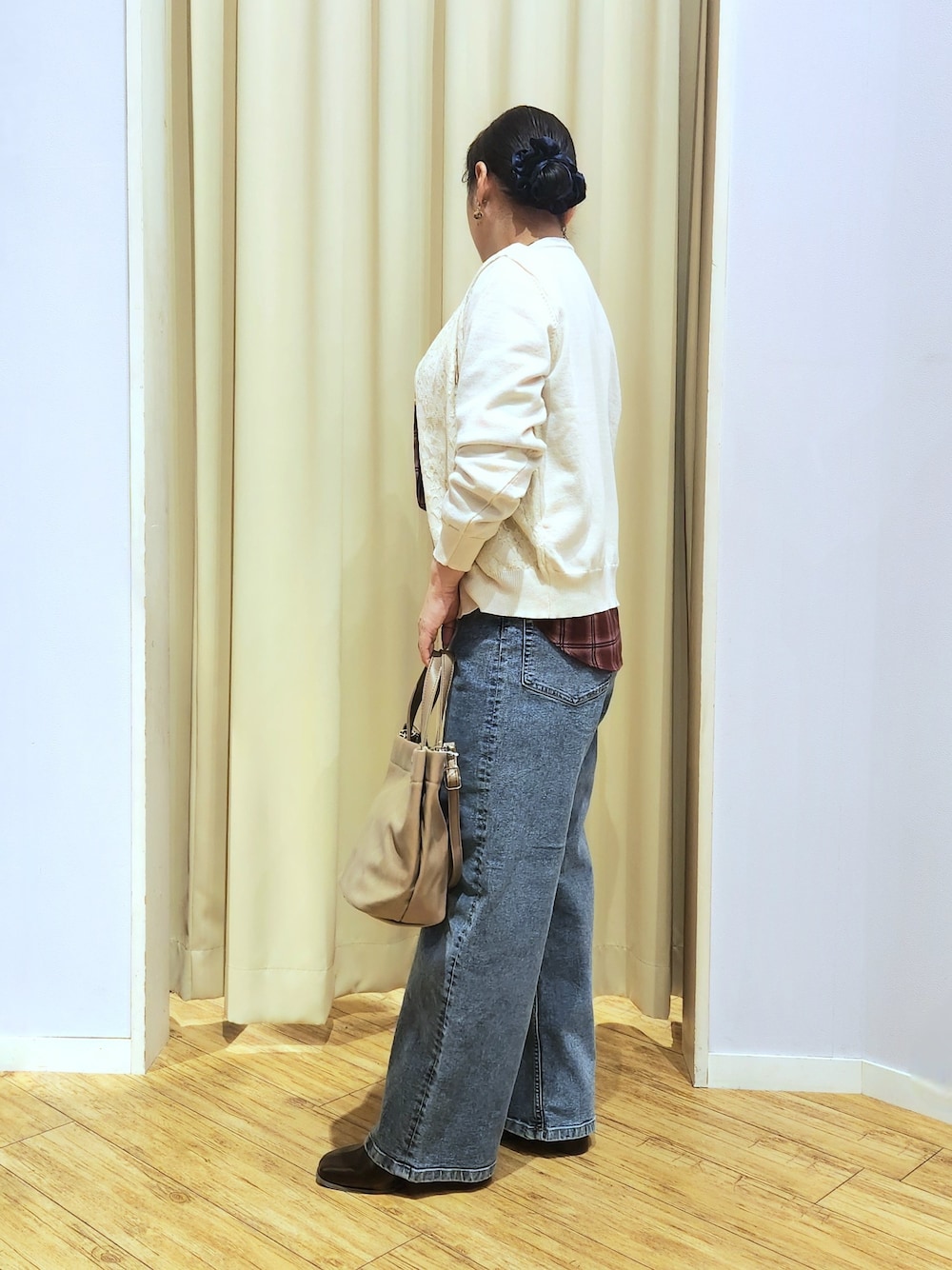 レッド系のシャツ/ブラウス、ホワイト系のカーディガン/ボレロ、ブルー系のデニムパンツを着用したレディースの秋コーディネートの4枚目の写真