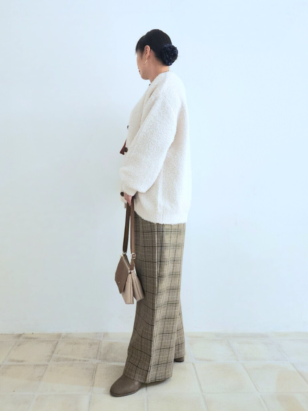 ベージュ系のショルダーバッグ、ブラウン系のブーツ、ベージュ系のカーディガン/ボレロを着用したレディースの秋コーディネートの2枚目の写真