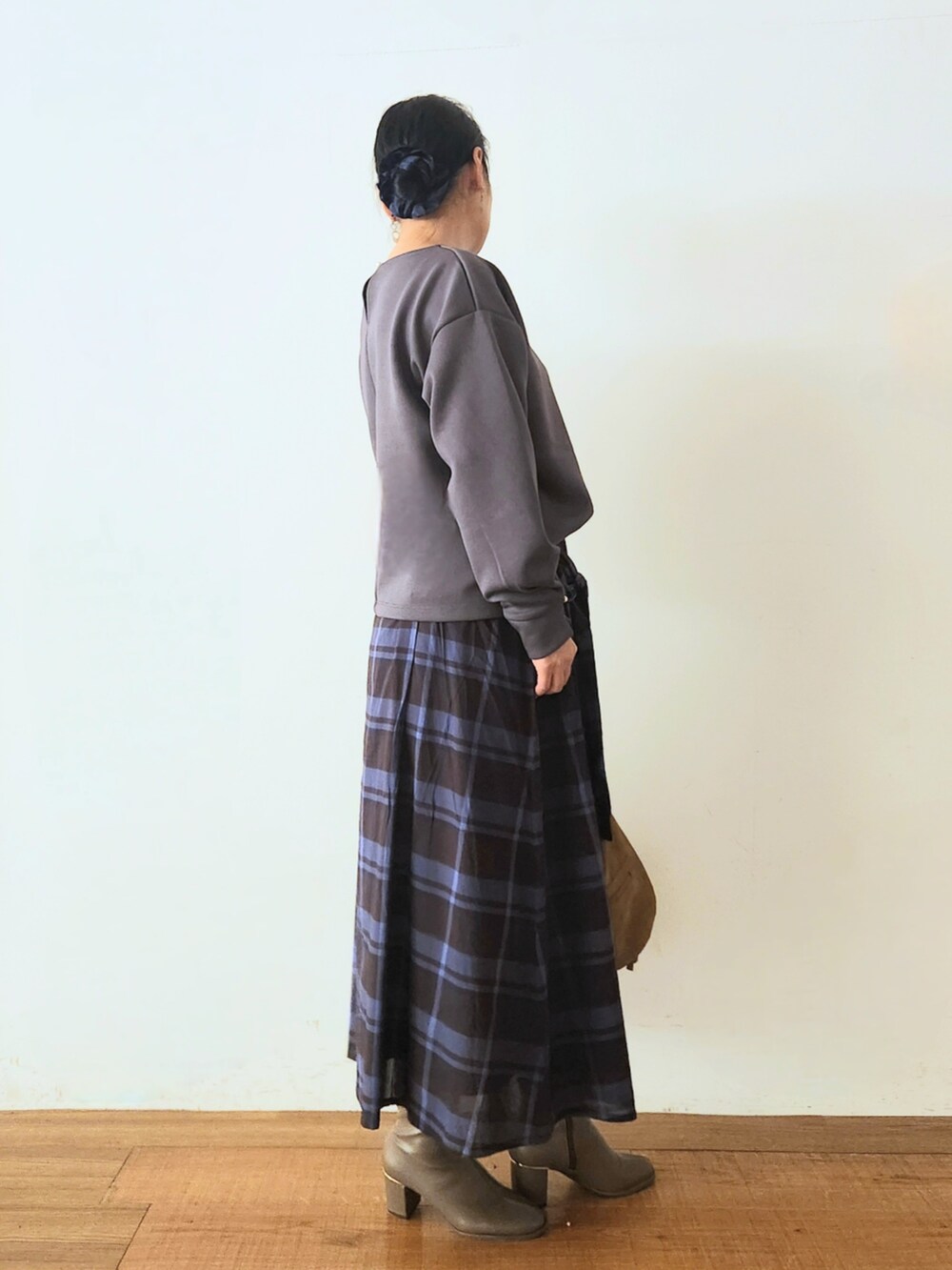 ブラウン系のブーツ、ブラック系のスカート、グレー系のTシャツ/カットソーを着用したレディースの秋コーディネートの2枚目の写真