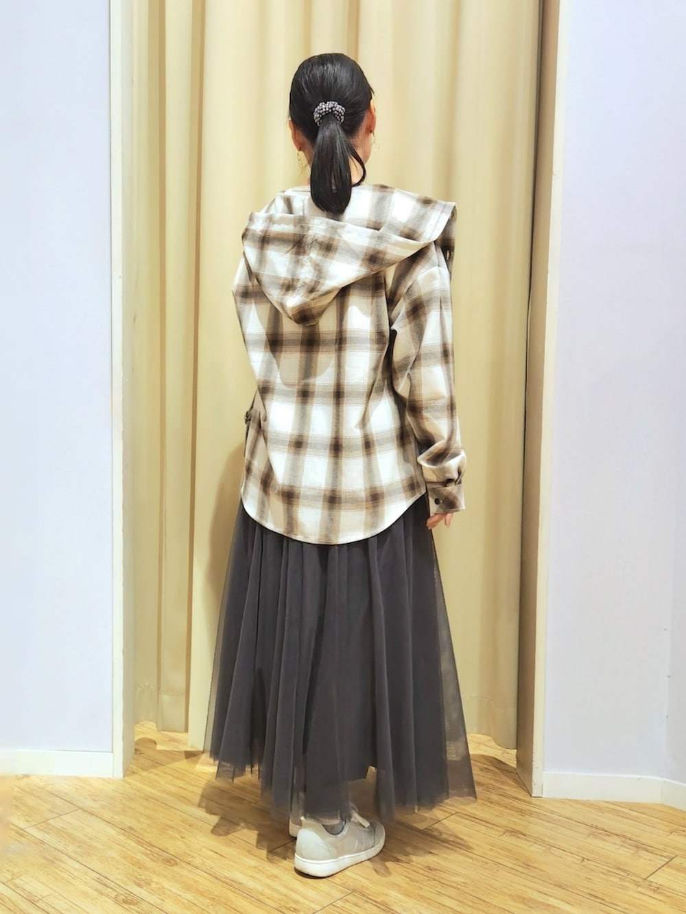 グレー系のスカート、シルバー系のショルダーバッグ、シルバー系のスニーカーを着用したレディースの春コーディネートの3枚目の写真