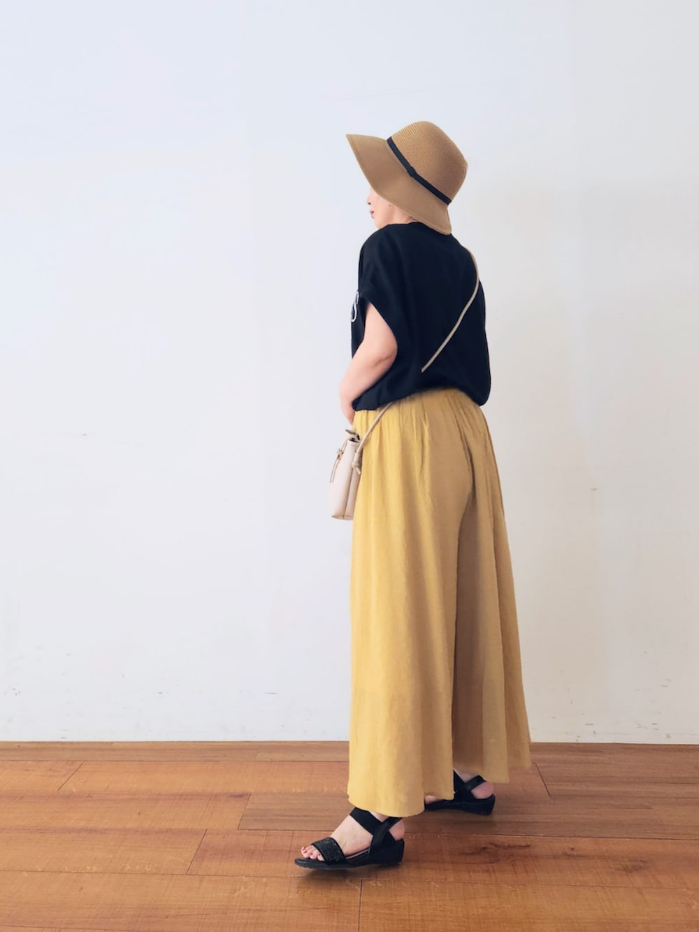 グレー系のショルダーバッグ、ブラック系のTシャツ/カットソー、イエロー系のその他パンツを着用したレディースの夏コーディネートの3枚目の写真