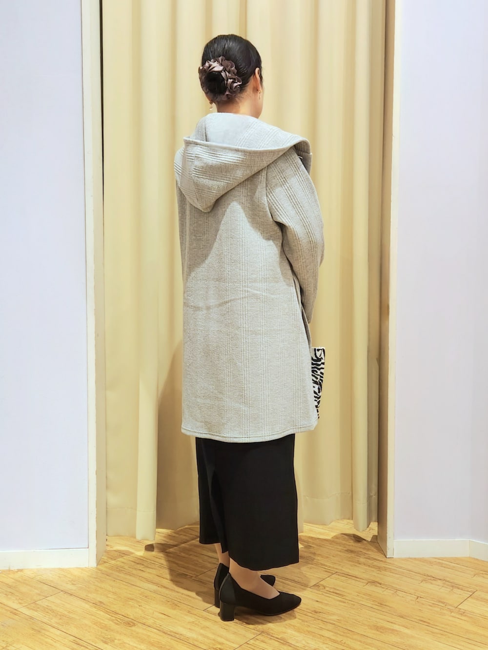 ブラック系のスカート、ブラック系のトートバッグ、ブラック系のパンプスを着用したレディースの冬コーディネートの4枚目の写真