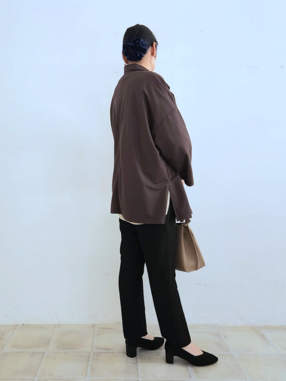 ブラック系のパンプス、ブラウン系のテーラードジャケット、ベージュ系のTシャツ/カットソーを着用したレディースの秋コーディネートの3枚目の写真