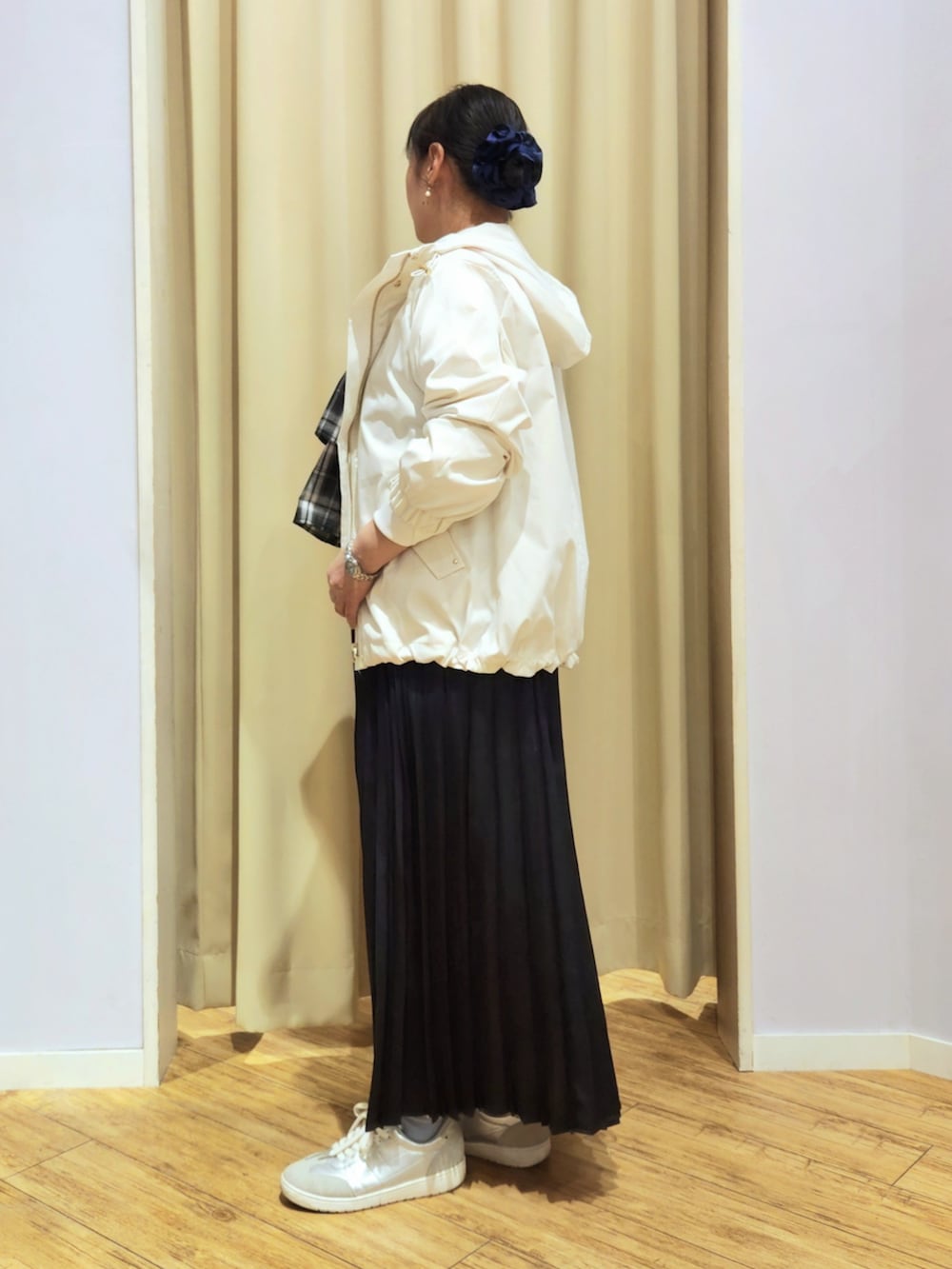 シルバー系のスニーカー、ブルー系のスカート、グレー系のショルダーバッグを着用したレディースの春コーディネートの2枚目の写真