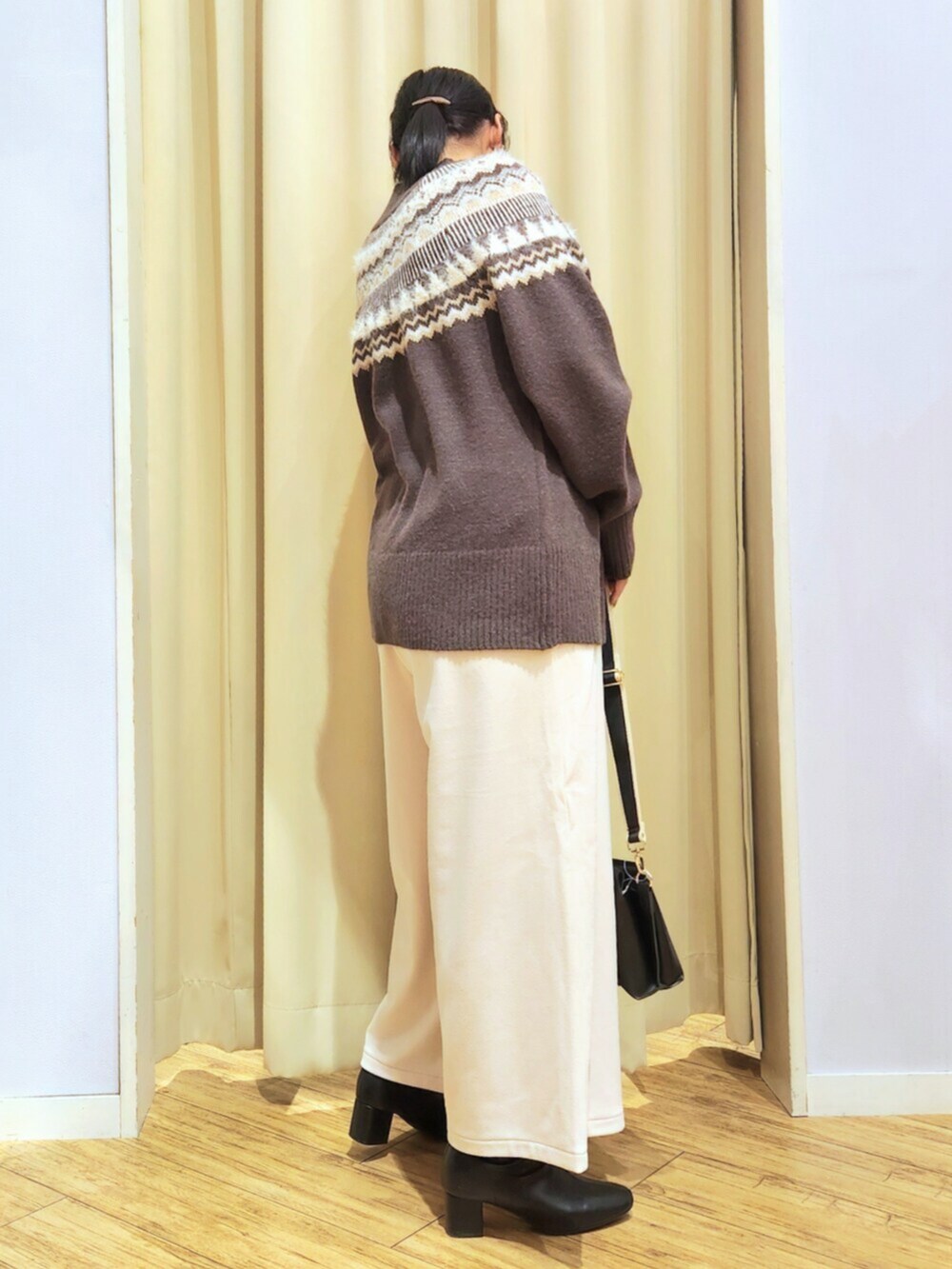 ホワイト系のその他パンツ、ブラウン系のニット/セーター、ブラック系のショルダーバッグを着用したレディースの冬コーディネートの4枚目の写真