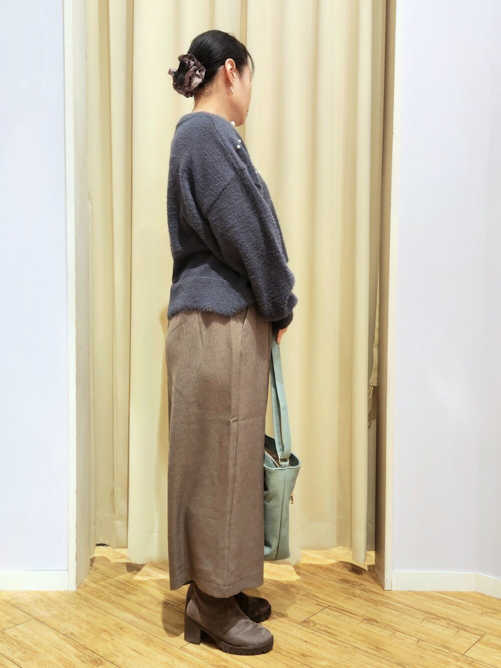 ブラウン系のブーツ、ブラウン系のその他パンツ、グリーン系のショルダーバッグを着用したレディースの冬コーディネートの2枚目の写真