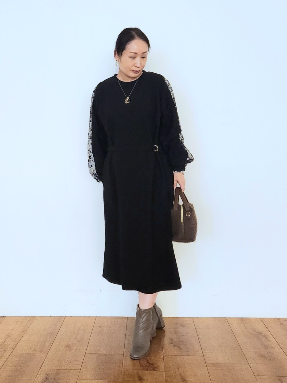 ブラウン系のブーツ、ブラック系のワンピース、ブラウン系のショルダーバッグを着用したレディースの秋コーディネートの4枚目の写真