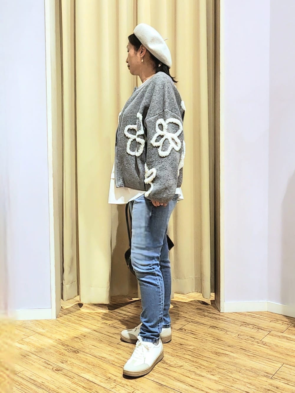 ホワイト系のスニーカー、ブラック系のボストンバッグ、ブルー系のデニムパンツを着用したレディースの冬コーディネートの2枚目の写真