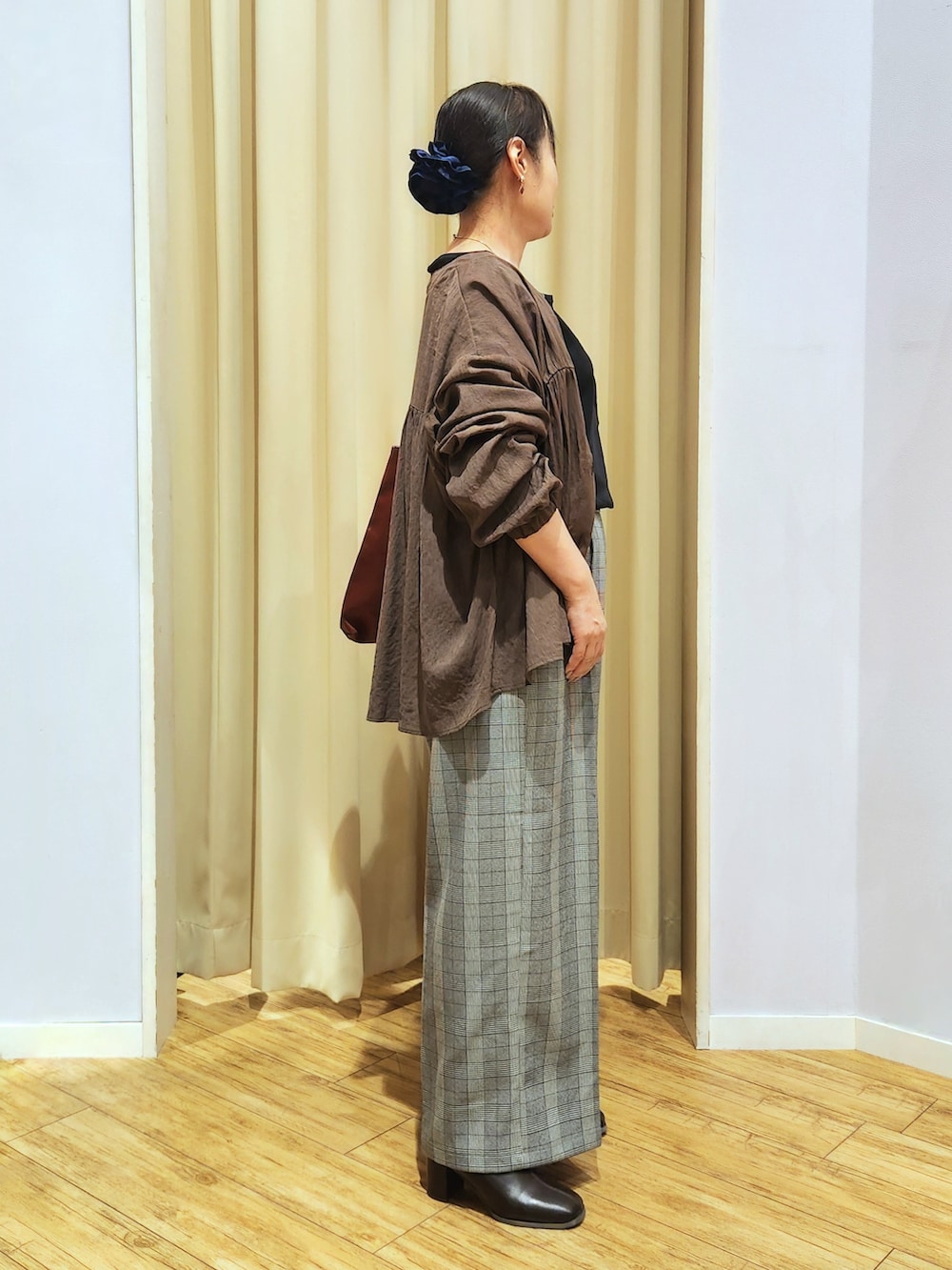 ブラック系のTシャツ/カットソー、グレー系のその他パンツ、ブラウン系のブーツを着用したレディースの秋コーディネートの3枚目の写真