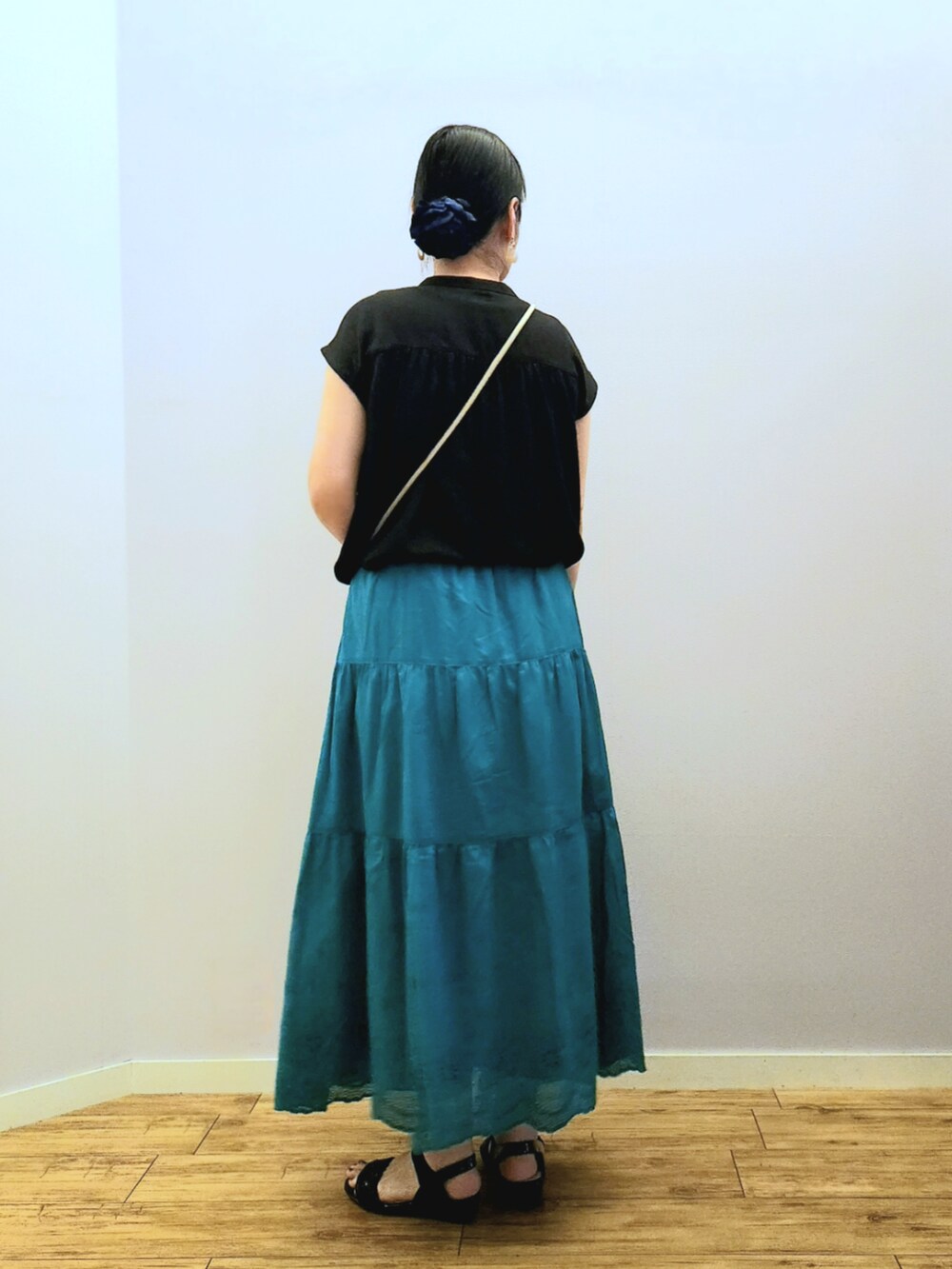 グレー系のショルダーバッグ、グリーン系のスカート、ブラック系のシャツ/ブラウスを着用したレディースの夏コーディネートの3枚目の写真