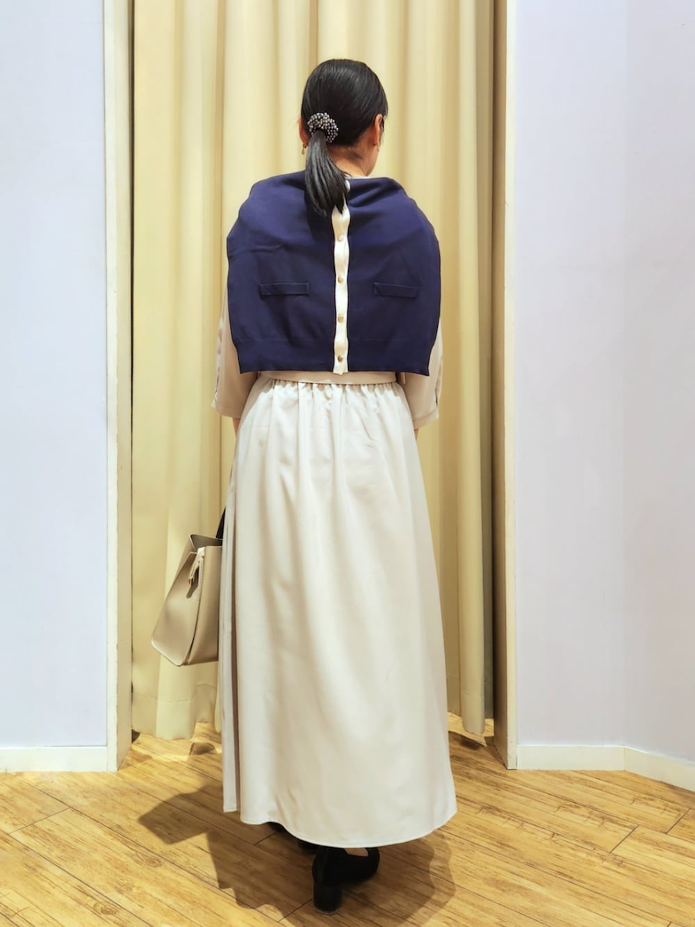 ブラック系のパンプス、ベージュ系のトートバッグ、ベージュ系のワンピースを着用したレディースの春コーディネートの4枚目の写真