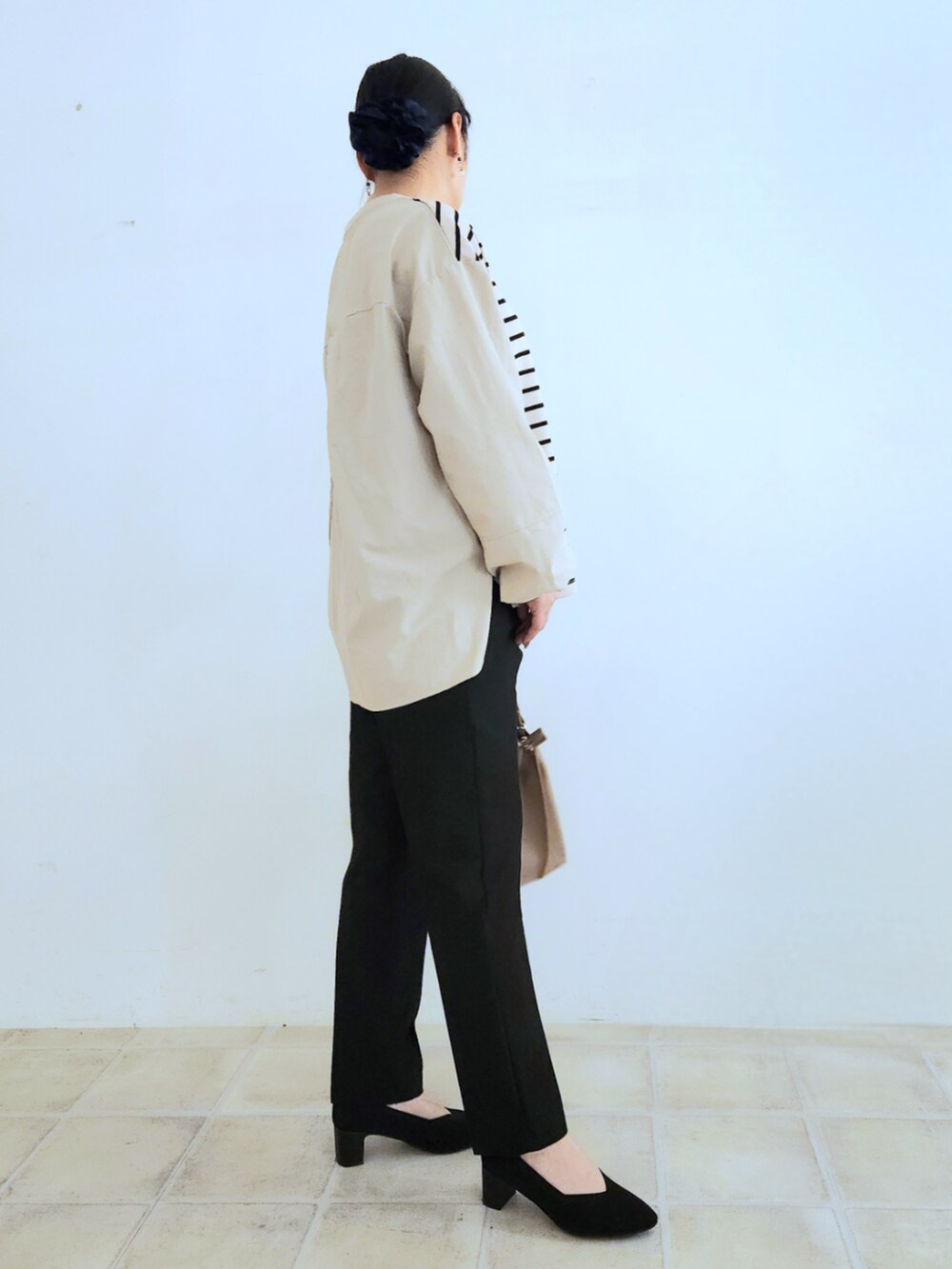 ブラック系のパンプス、ブラウン系のテーラードジャケット、ベージュ系のTシャツ/カットソーを着用したレディースの秋コーディネートの6枚目の写真