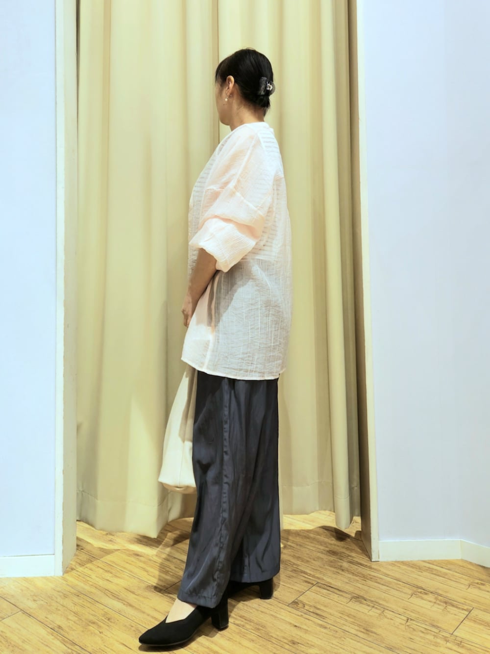 ブラック系のパンプス、グレー系のその他パンツ、ベージュ系のショルダーバッグを着用したレディースの春コーディネートの2枚目の写真