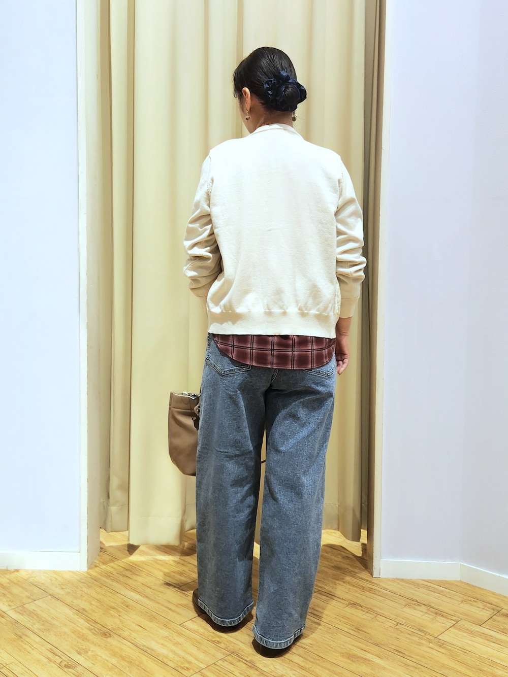 レッド系のシャツ/ブラウス、ホワイト系のカーディガン/ボレロ、ブルー系のデニムパンツを着用したレディースの秋コーディネートの6枚目の写真