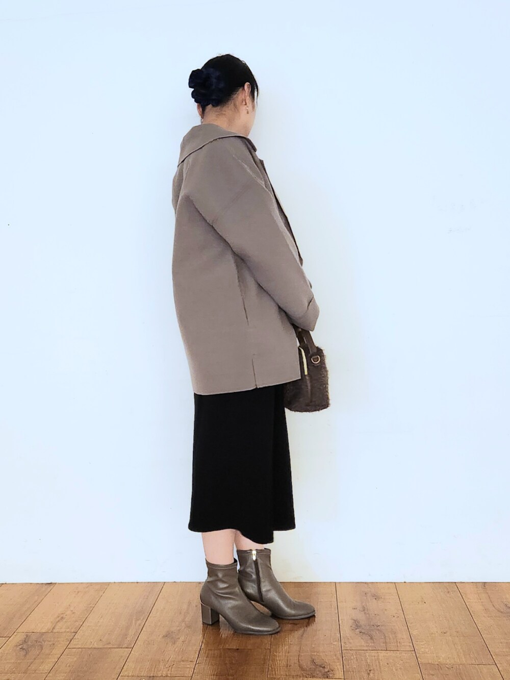 ブラウン系のブーツ、ブラック系のワンピース、ブラウン系のショルダーバッグを着用したレディースの秋コーディネートの2枚目の写真