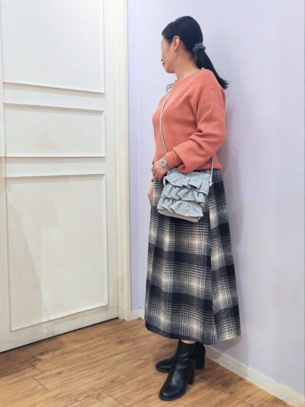 ブラック系のブーツ、ピンク系のニット/セーター、ブラック系のスカートを着用したレディースの秋コーディネートの2枚目の写真