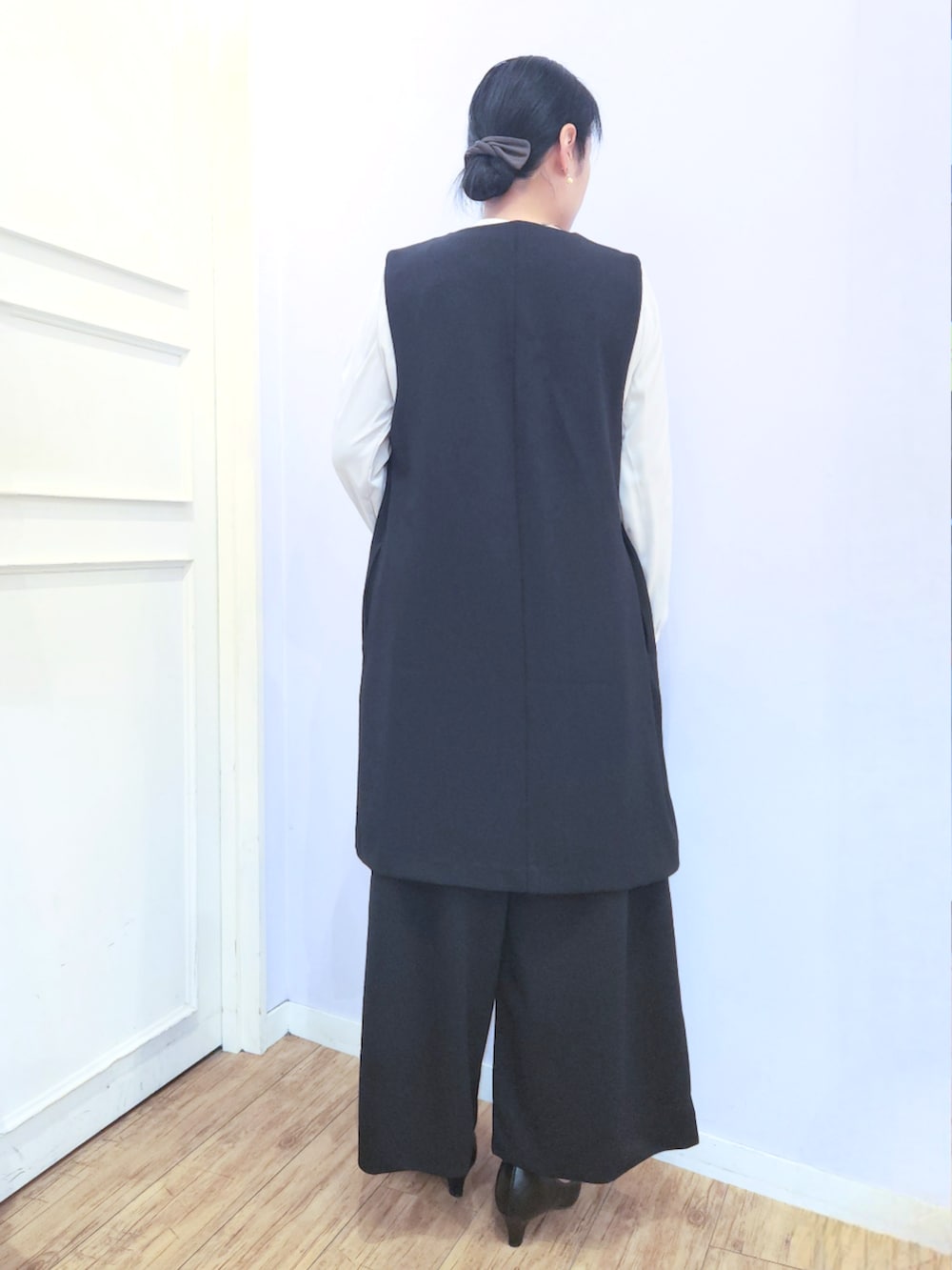 ブラック系のパンプス、ブラック系のベスト、ブラック系のその他パンツを着用したレディースの冬コーディネートの4枚目の写真