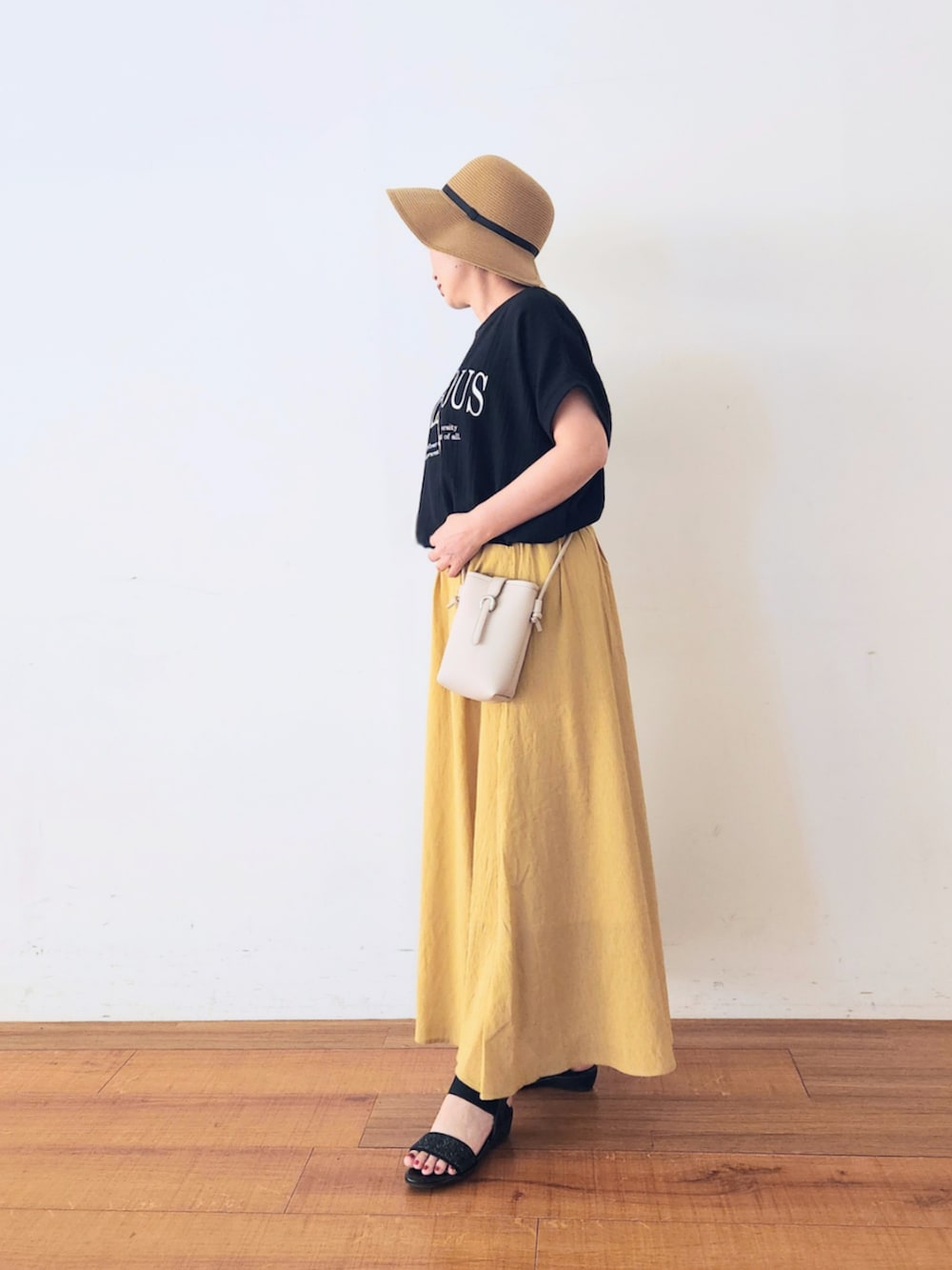 グレー系のショルダーバッグ、ブラック系のTシャツ/カットソー、イエロー系のその他パンツを着用したレディースの夏コーディネートの2枚目の写真