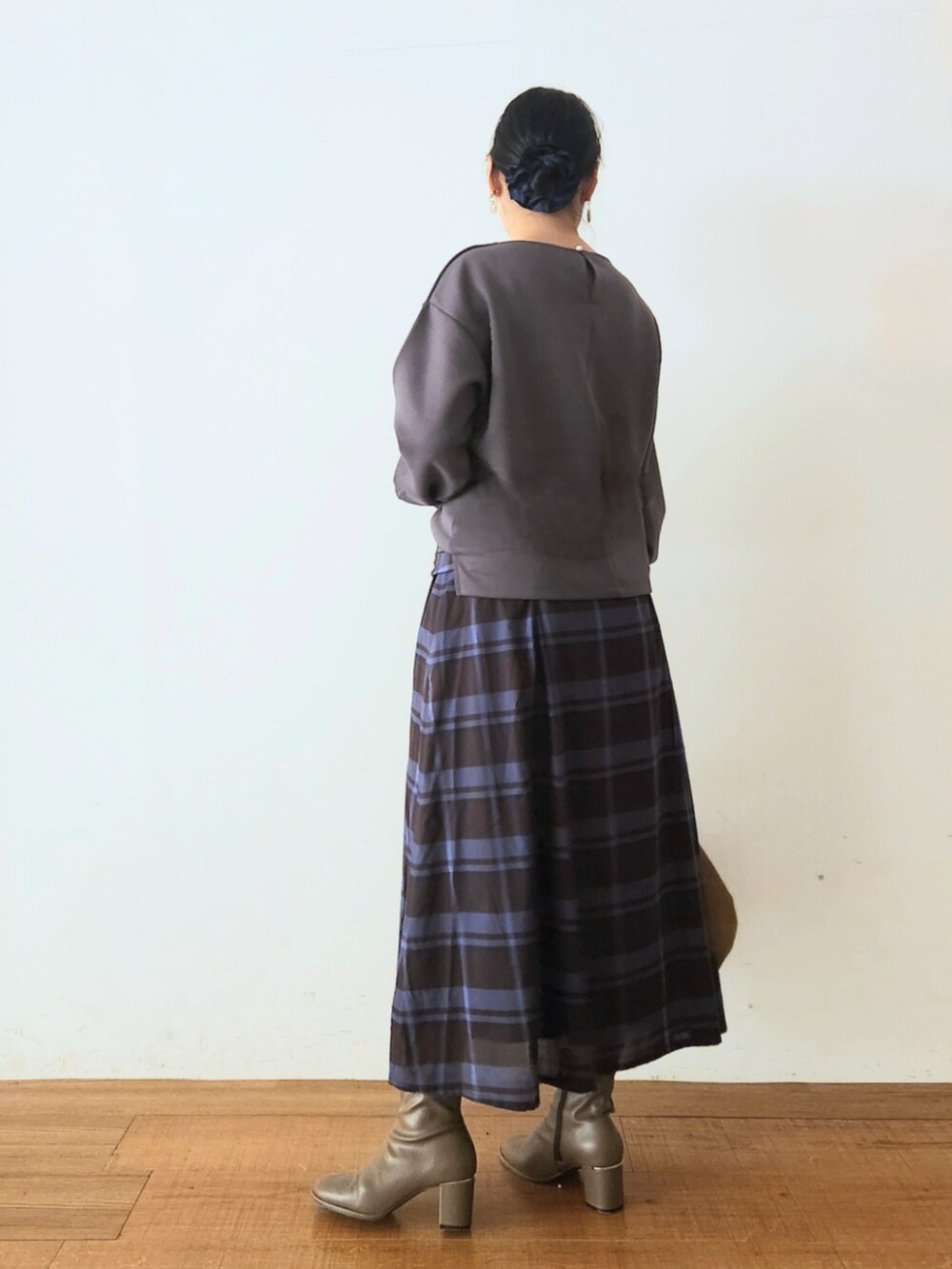 ブラウン系のブーツ、ブラック系のスカート、グレー系のTシャツ/カットソーを着用したレディースの秋コーディネートの3枚目の写真