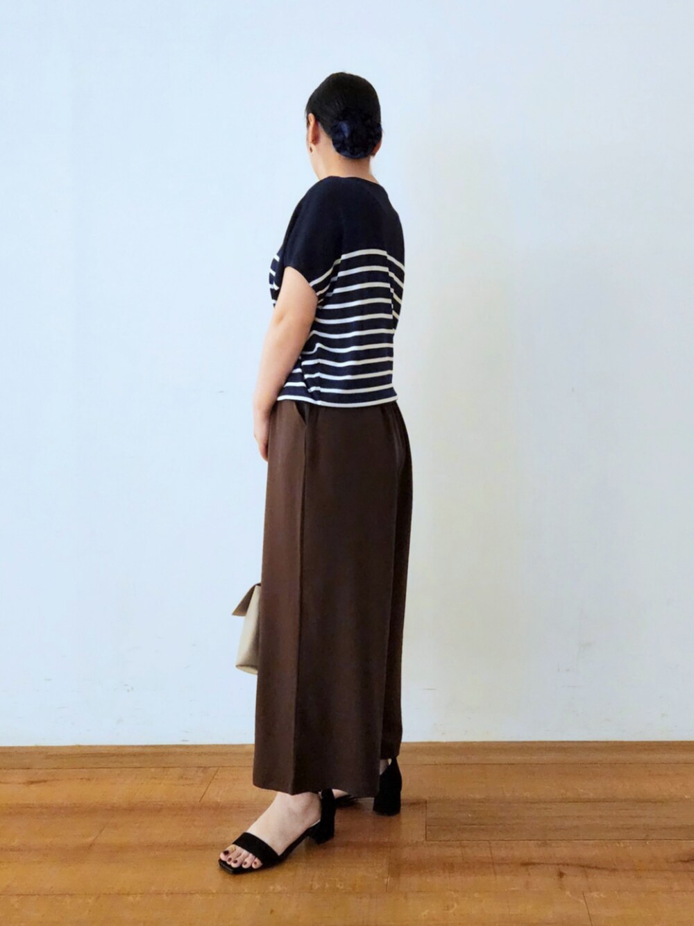 ブルー系のニット/セーター、ブラック系のサンダル、ブラウン系のその他パンツを着用したレディースの夏コーディネートの2枚目の写真