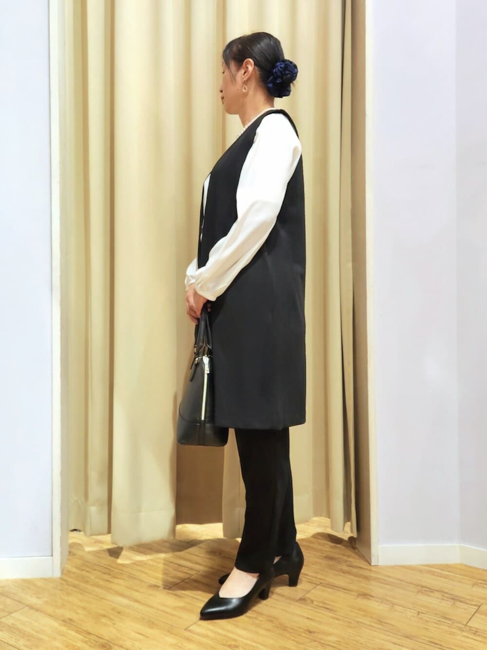 ブラック系のその他パンツ、ブラック系のパンプス、ブラック系のトートバッグを着用したレディースの冬コーディネートの2枚目の写真