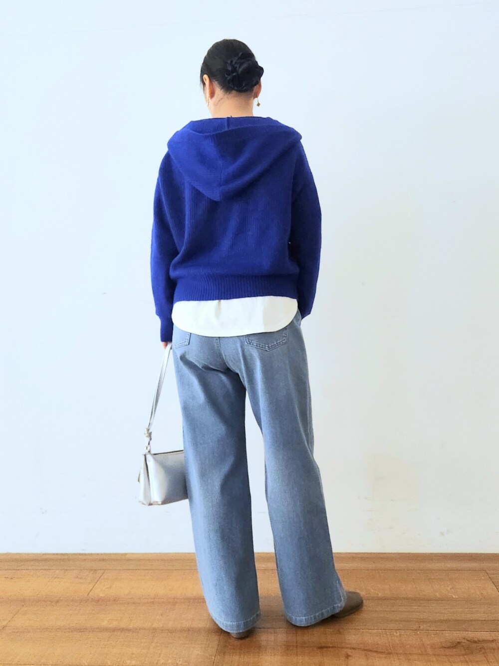 シルバー系のショルダーバッグ、ブラウン系のブーツ、ブルー系のニット/セーターを着用したレディースの秋コーディネートの3枚目の写真