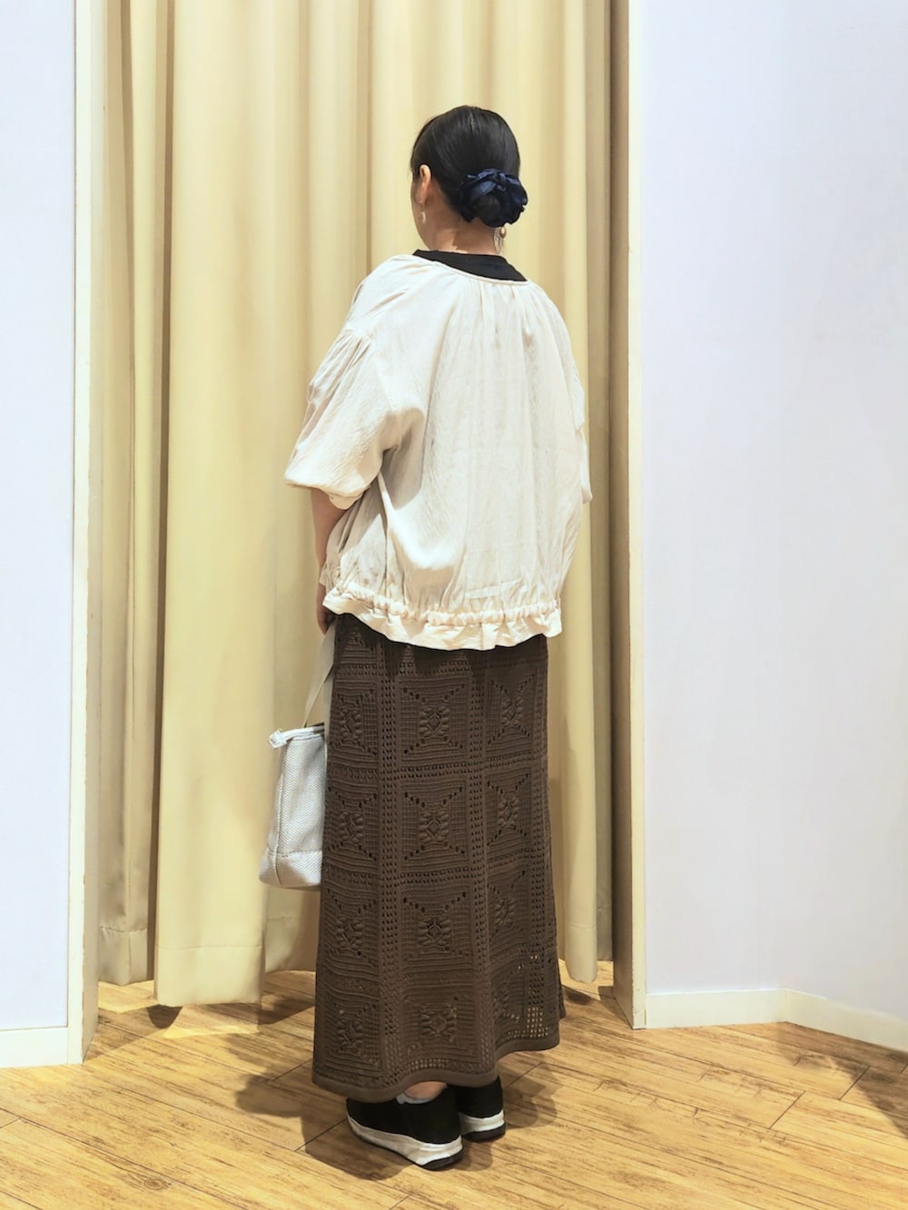 ブラック系のスニーカー、ブラウン系のスカート、ブラック系のTシャツ/カットソーを着用したレディースの夏コーディネートの4枚目の写真