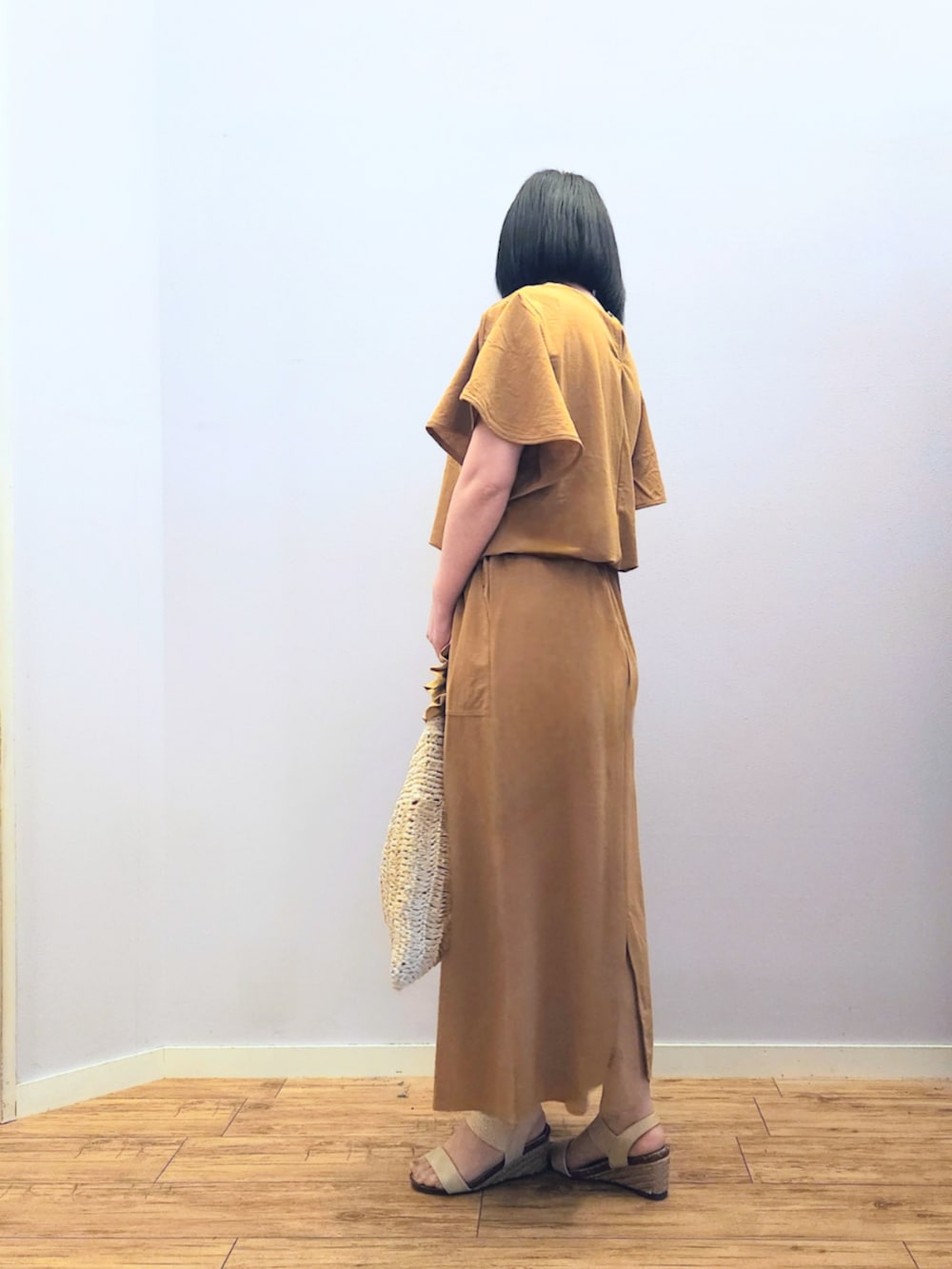 ゴールド系のサンダル、イエロー系のトートバッグ、イエロー系のスカートを着用したレディースの夏コーディネートの4枚目の写真