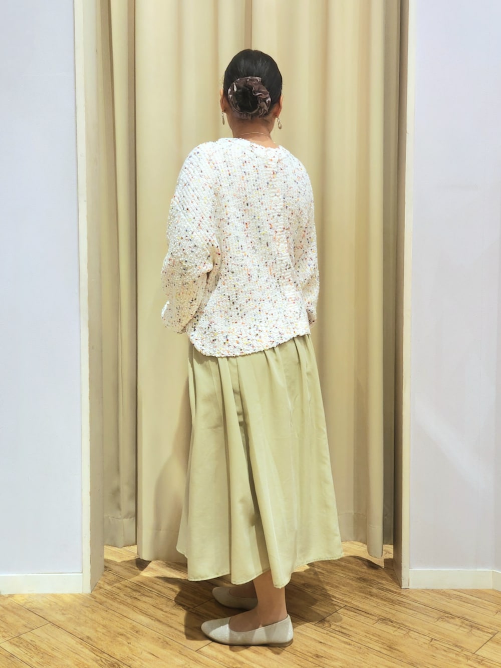 ホワイト系のカーディガン/ボレロ、ベージュ系のパンプス、グリーン系のスカートを着用したレディースの冬コーディネートの3枚目の写真