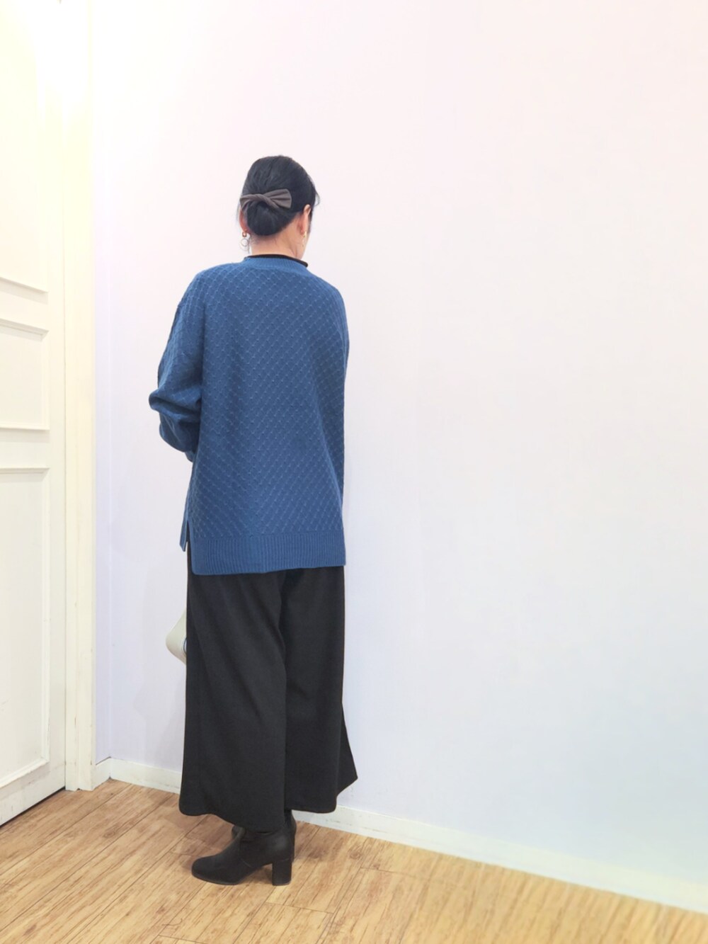 ブラック系のブーツ、ブルー系のニット/セーター、シルバー系のショルダーバッグを着用したレディースの冬コーディネートの3枚目の写真