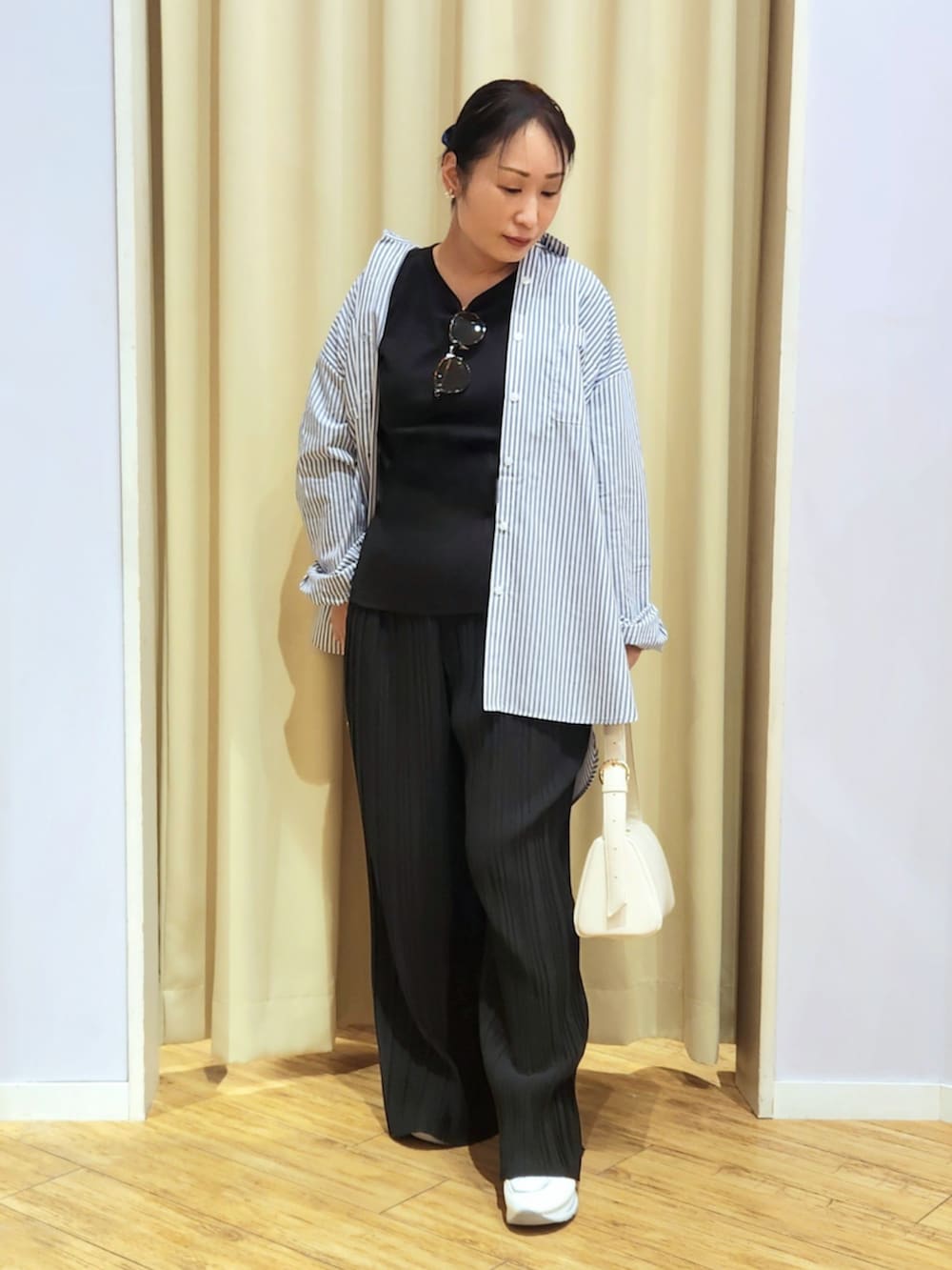 ホワイト系のショルダーバッグ、ホワイト系のTシャツ/カットソー、ホワイト系のスニーカーを着用したレディースの春コーディネートの4枚目の写真