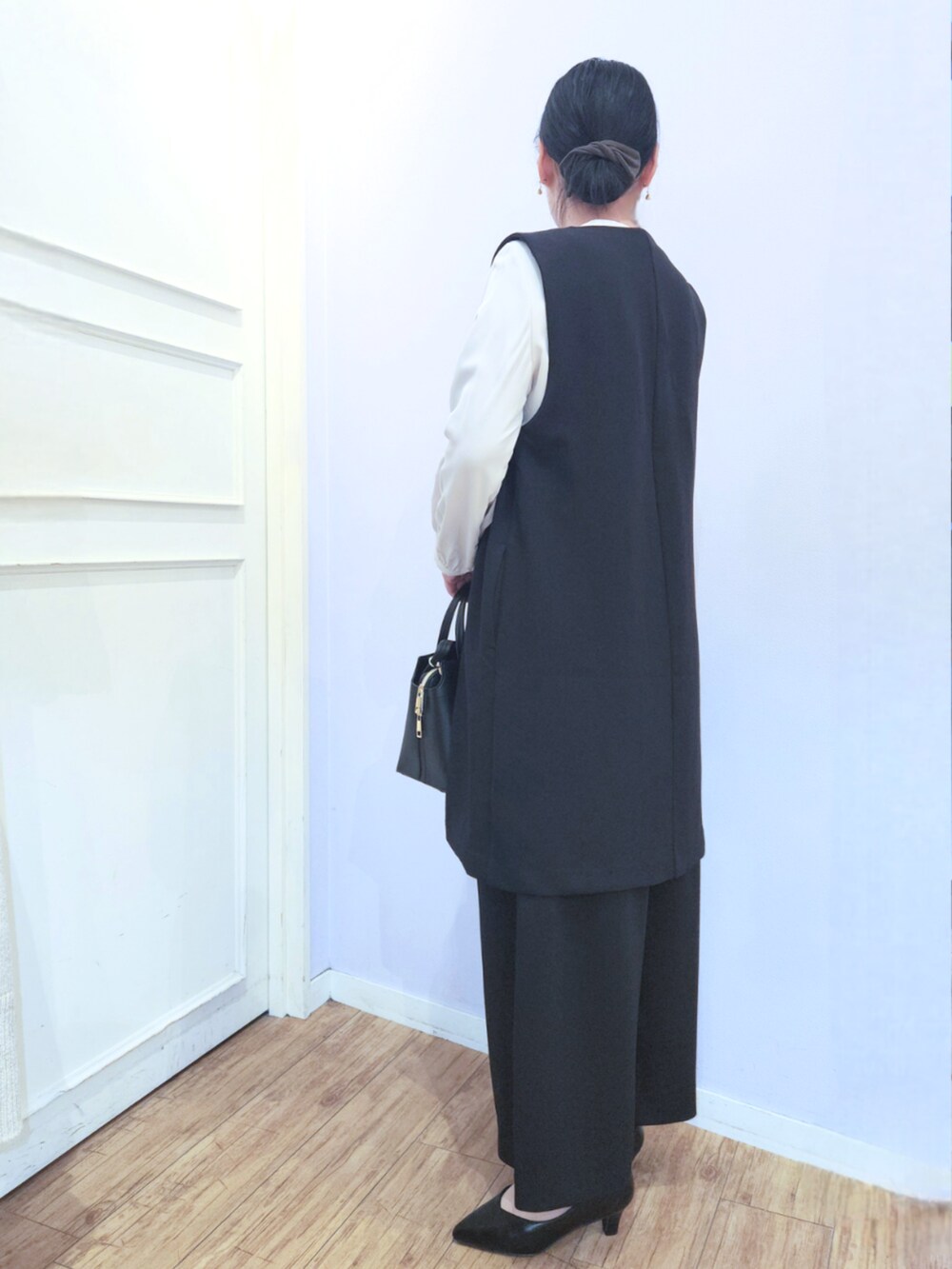 ブラック系のパンプス、ブラック系のベスト、ブラック系のその他パンツを着用したレディースの冬コーディネートの3枚目の写真