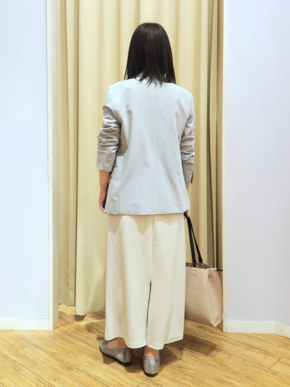 シルバー系のその他シューズ、ベージュ系のトートバッグ、ベージュ系のスカートを着用したレディースの春コーディネートの3枚目の写真