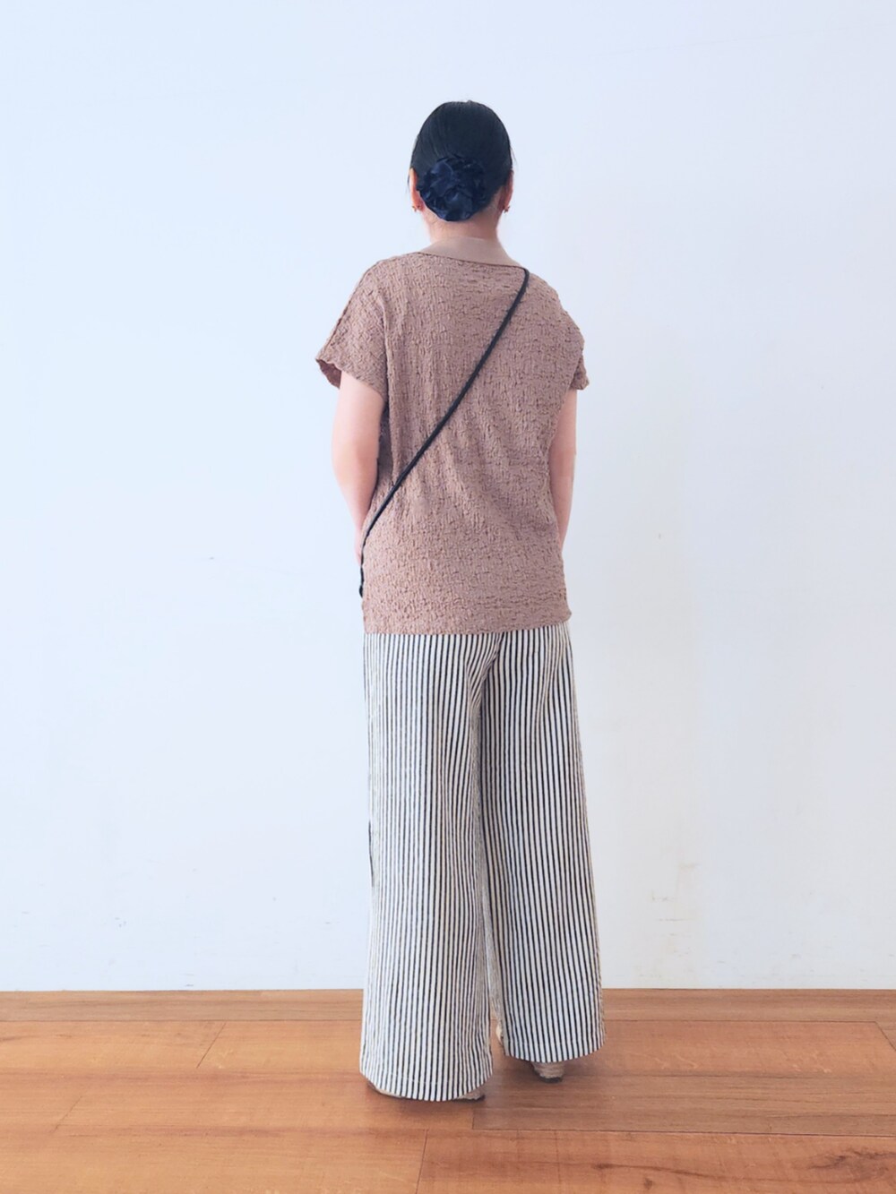 ゴールド系のサンダル、ブラック系のショルダーバッグ、ブルー系のその他パンツを着用したレディースの夏コーディネートの3枚目の写真