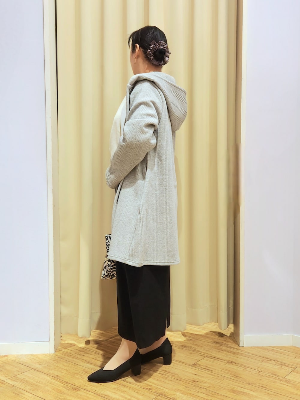 ブラック系のスカート、ブラック系のトートバッグ、ブラック系のパンプスを着用したレディースの冬コーディネートの3枚目の写真