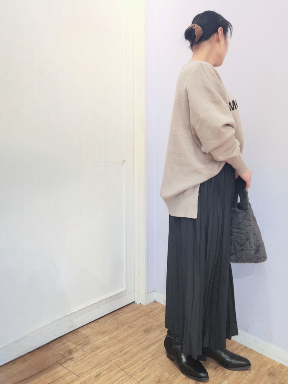 ブラック系のブーツ、ブラウン系のニット/セーター、ブラック系のスカートを着用したレディースの冬コーディネートの2枚目の写真