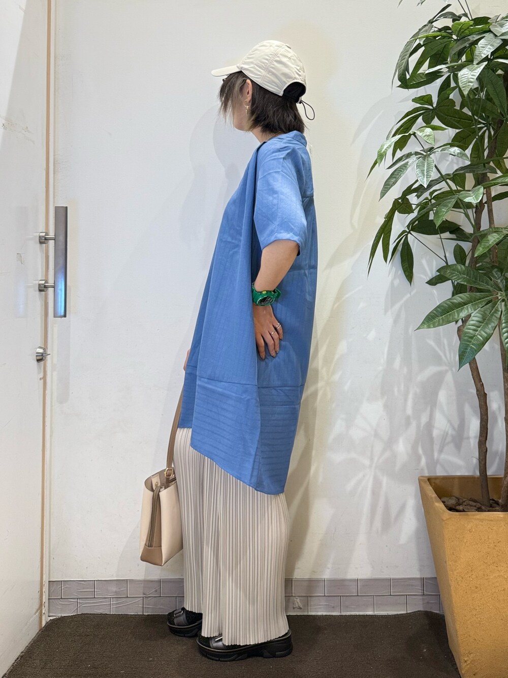 ブルー系のチュニック、ホワイト系のその他パンツ、シルバー系のサンダルを着用したレディースの春コーディネートの3枚目の写真