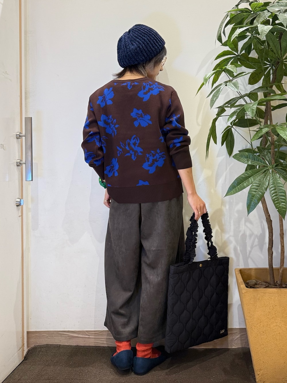 ブラウン系のニット/セーター、グレー系のその他パンツ、ブラック系のトートバッグを着用したレディースの秋コーディネートの4枚目の写真