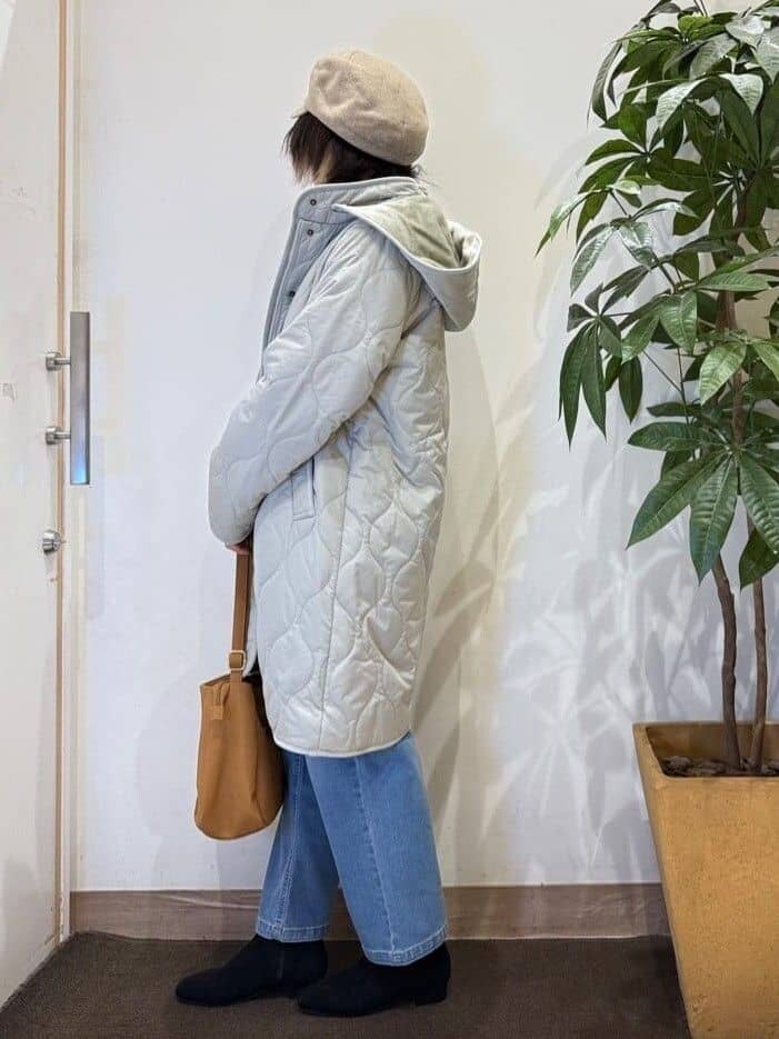 グリーン系のその他アウター、ブラウン系のニット/セーター、ブルー系のデニムパンツを着用したレディースの秋コーディネートの3枚目の写真