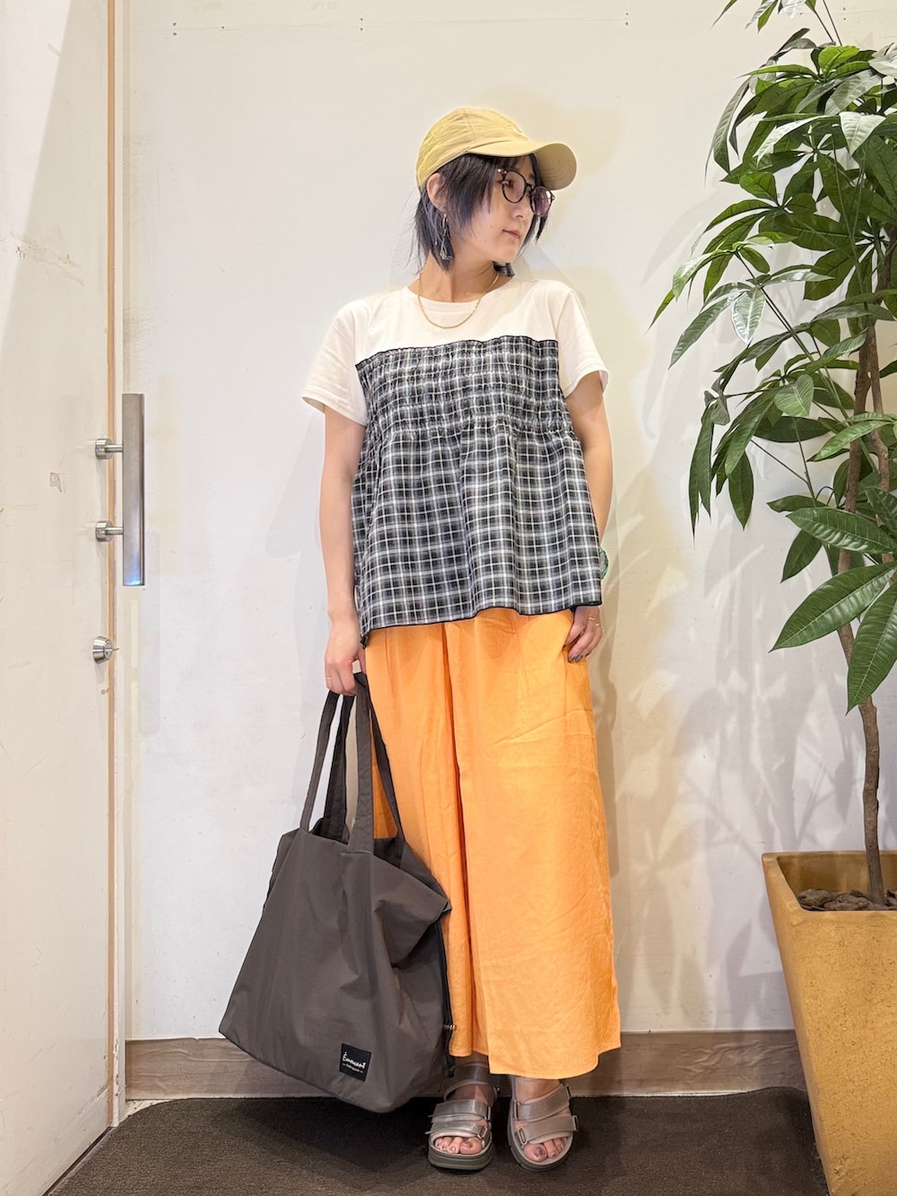 ブラック系のTシャツ/カットソー、オレンジ系のその他パンツ、ブラウン系のサンダルを着用したレディースの夏コーディネートの2枚目の写真