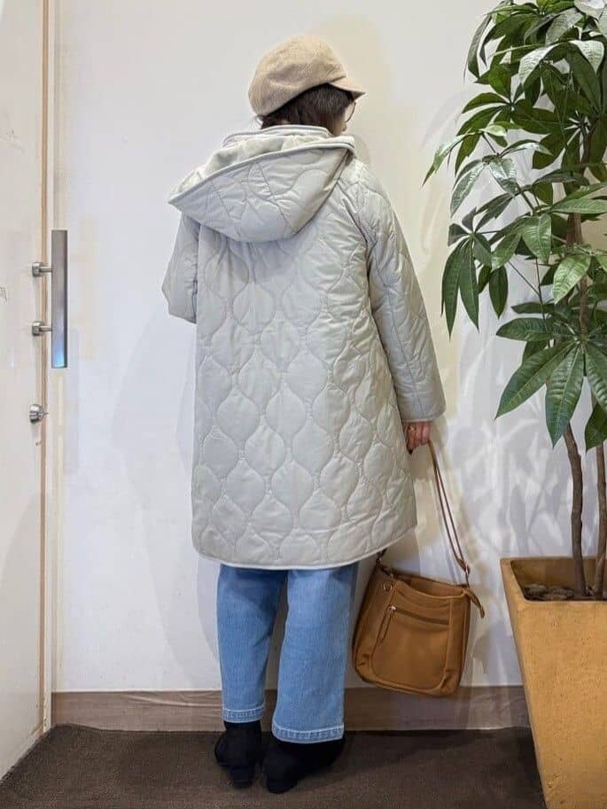 グリーン系のその他アウター、ブラウン系のニット/セーター、ブルー系のデニムパンツを着用したレディースの秋コーディネートの4枚目の写真