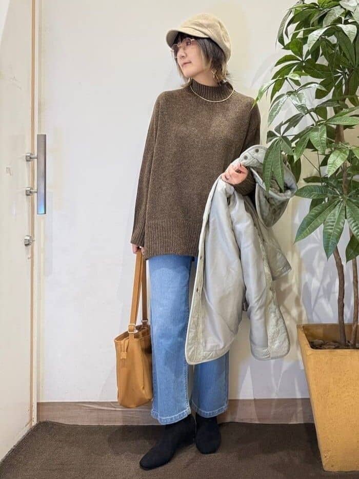 グリーン系のその他アウター、ブラウン系のニット/セーター、ブルー系のデニムパンツを着用したレディースの秋コーディネートの5枚目の写真