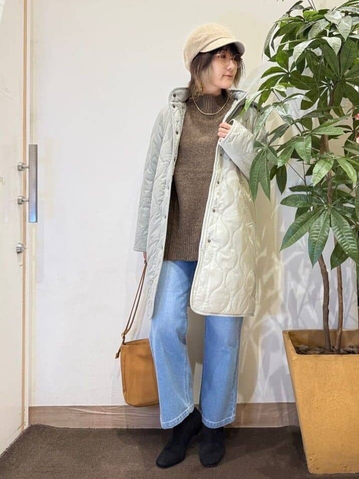 グリーン系のその他アウター、ブラウン系のニット/セーター、ブルー系のデニムパンツを着用したレディースの秋コーディネートの2枚目の写真