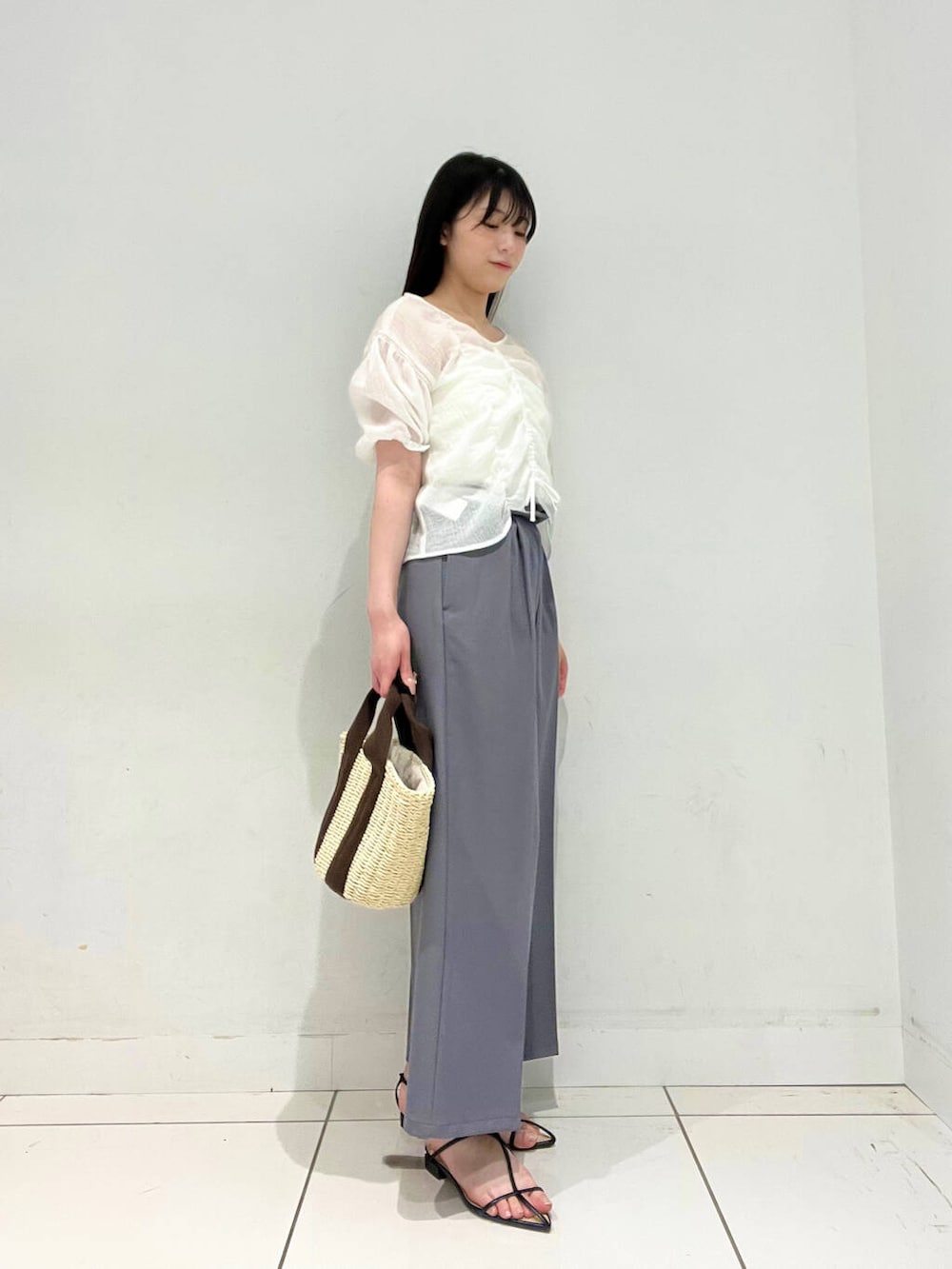 ホワイト系のハンドバッグ、グレー系のその他パンツ、ホワイト系のキャミソールを着用したレディースの春コーディネートの2枚目の写真