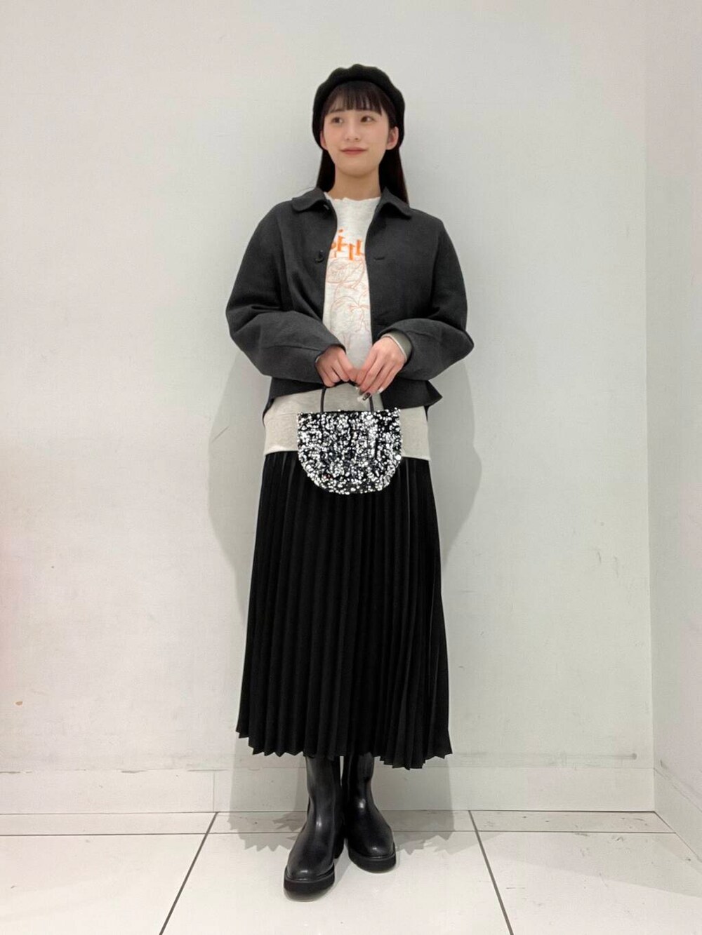 シルバー系のショルダーバッグ、グレー系のブルゾン、ブラック系のブーツを着用したレディースの秋コーディネートの3枚目の写真