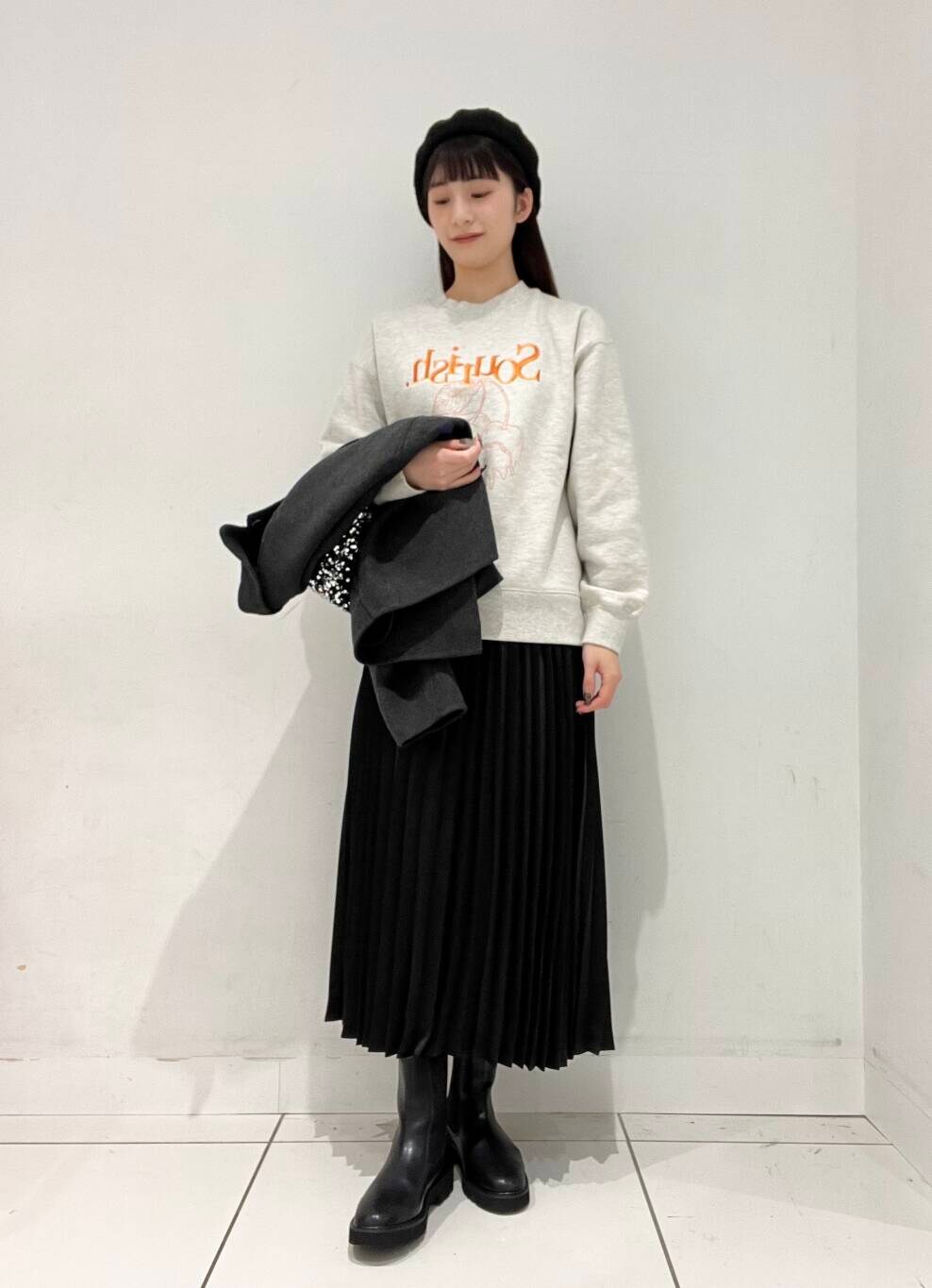 シルバー系のショルダーバッグ、グレー系のブルゾン、ブラック系のブーツを着用したレディースの秋コーディネートの4枚目の写真